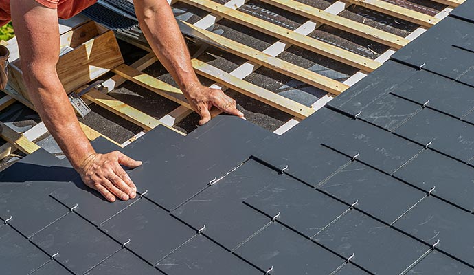 Professional worker installing stalling slate roof