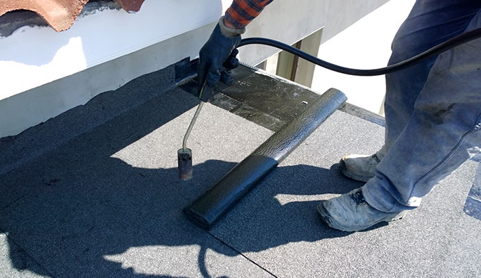 The worker installed roll roofing on the roof.