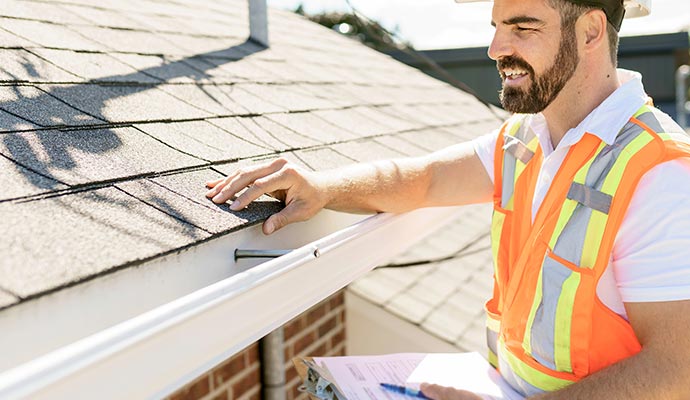 Professional worker inspecting roof